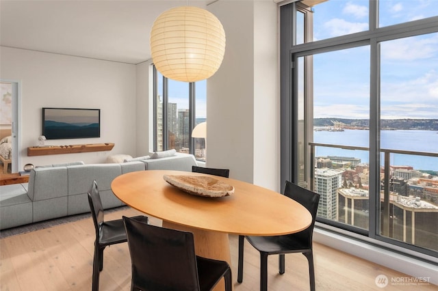 2510 6th Ave Unit 3605, Seattle, WA 98121 - dining space with a water view, light wood-style floors, and expansive windows