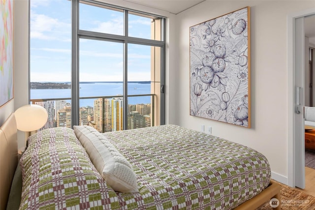 2510 6th Ave Unit 3605, Seattle, WA 98121 - bedroom with a water view, multiple windows, floor to ceiling windows, wood finished floors, and a city view