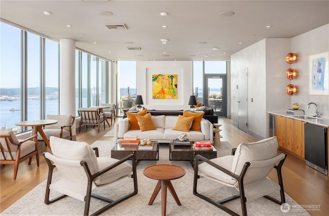 2510 6th Ave Unit 3605, Seattle, WA 98121 - living area with light wood-style floors, a water view, floor to ceiling windows, and recessed lighting