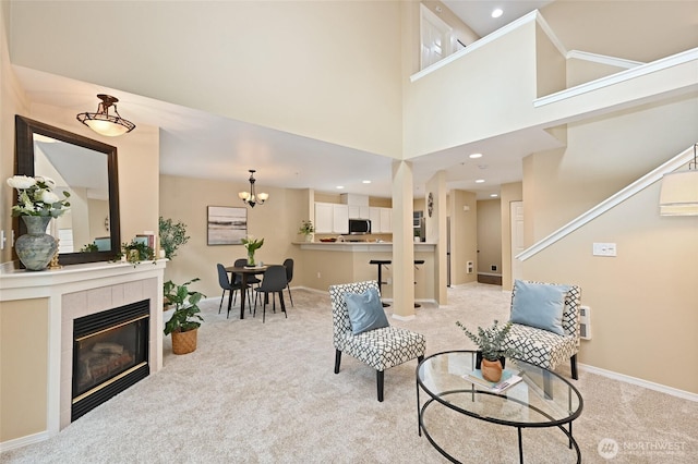 2001 120th Pl SE Unit 7-101, Everett, WA 98208 - living room with light carpet, a fireplace, stairway, a high ceiling, and a chandelier