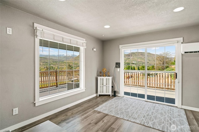 2440 Rock Island Rd, East Wenatchee, WA 98802 - doorway with a wall mounted AC, wood finished floors, plenty of natural light, recessed lighting, and a textured ceiling