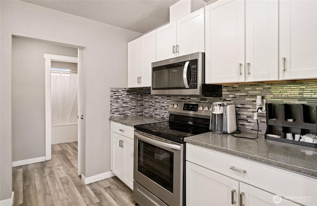 2440 Rock Island Rd, East Wenatchee, WA 98802 - kitchen featuring stainless steel appliances, light wood-style flooring, dark stone counters, tasteful backsplash, and white cabinets