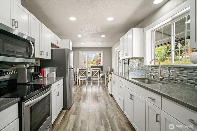 2440 Rock Island Rd, East Wenatchee, WA 98802 - kitchen featuring appliances with stainless steel finishes, a textured ceiling, recessed lighting, decorative backsplash, and wood finished floors