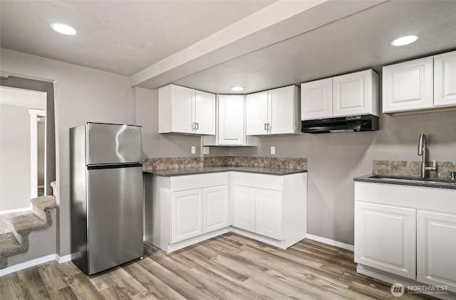 2440 Rock Island Rd, East Wenatchee, WA 98802 - kitchen with freestanding refrigerator, under cabinet range hood, light wood finished floors, white cabinets, and recessed lighting