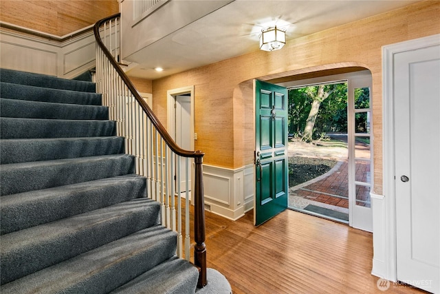 2425 Evergreen Point Rd, Medina, WA 98039 - entryway featuring wood finished floors, stairway, a decorative wall, wainscoting, and arched walkways