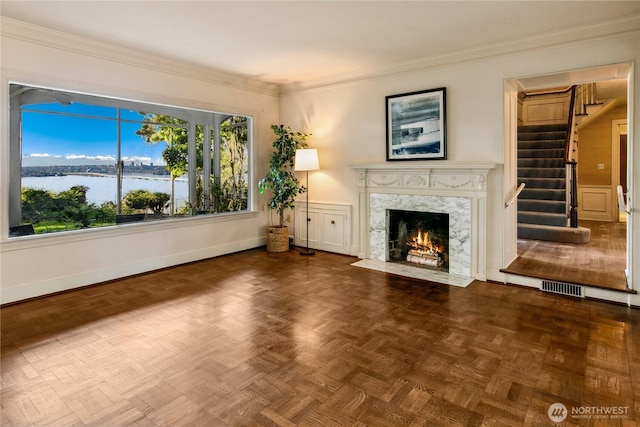 2425 Evergreen Point Rd, Medina, WA 98039 - unfurnished living room featuring stairs, a high end fireplace, ornamental molding, and a water view