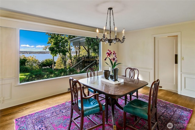 2425 Evergreen Point Rd, Medina, WA 98039 - dining area featuring wood finished floors, ornamental molding, a chandelier, and a wainscoted wall