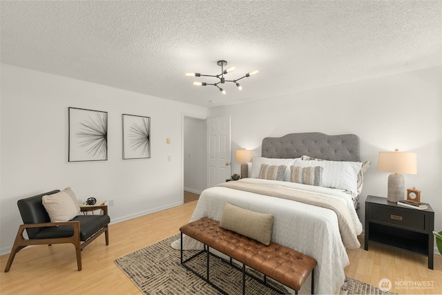 7812 196th St SW Unit B2, Edmonds, WA 98026 - bedroom featuring a chandelier, light wood-style floors, and a textured ceiling