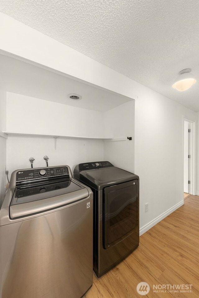 7812 196th St SW Unit B2, Edmonds, WA 98026 - laundry area with washer and dryer, light wood-type flooring, and a textured ceiling
