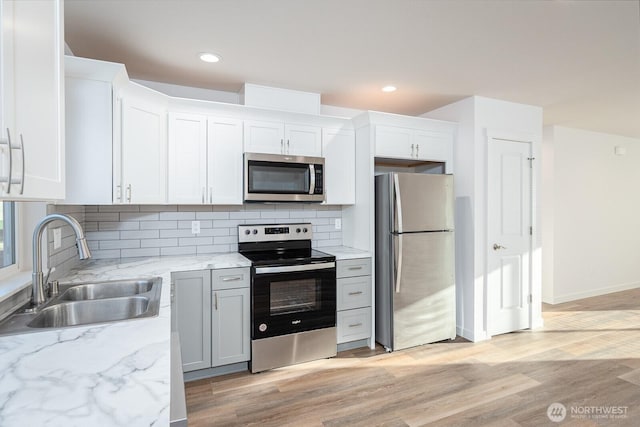 1325 Shaw St, Moses Lake, WA 98837 - kitchen featuring stainless steel appliances, light wood-style flooring, decorative backsplash, light stone countertops, and recessed lighting