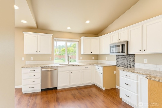 20211 85th Avenue Ct E, Spanaway, WA 98387 - kitchen with stainless steel appliances, light wood-style flooring, vaulted ceiling, white cabinetry, and recessed lighting