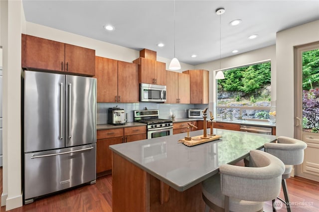 1129 Birch Falls Dr, Bellingham, WA 98229 - kitchen featuring stainless steel appliances, dark wood finished floors, backsplash, pendant lighting, and a kitchen breakfast bar