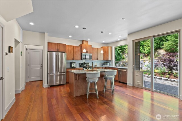 1129 Birch Falls Dr, Bellingham, WA 98229 - kitchen with stainless steel appliances, a center island, brown cabinets, dark wood-style flooring, and recessed lighting