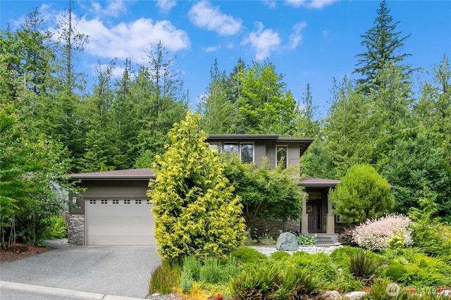 1129 Birch Falls Dr, Bellingham, WA 98229 - view of property hidden behind natural elements with concrete driveway, stone siding, and a garage