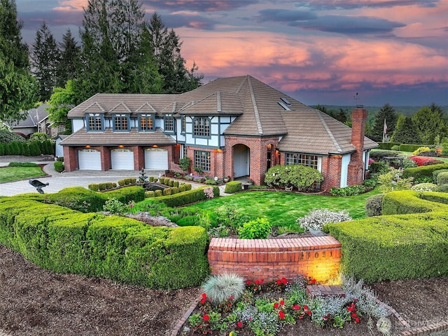 21031 49th Ave SE, Bothell, WA 98021 - tudor-style house featuring brick siding, driveway, a tiled roof, a chimney, and an attached garage