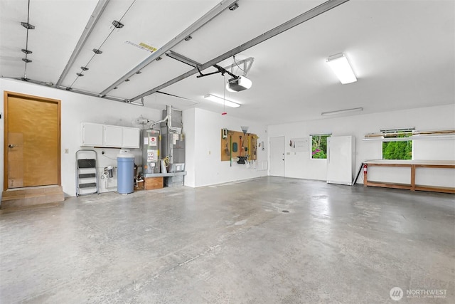 5788 Hannegan Rd, Bellingham, WA 98226 - garage featuring a garage door opener, water heater, and freestanding refrigerator