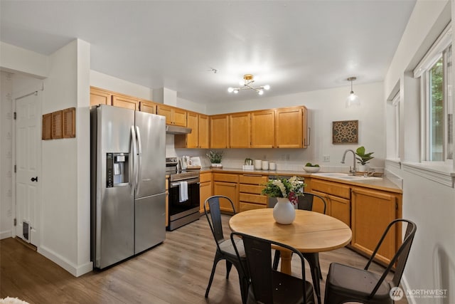 10307 140th Street Ct E Unit 3, Puyallup, WA 98374 - kitchen with stainless steel appliances, light wood finished floors, light countertops, and under cabinet range hood