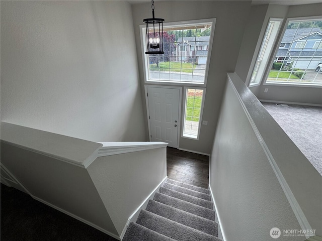 20116 85th Avenue Ct E, Spanaway, WA 98387 - staircase with a chandelier, carpet, a textured wall, and wood finished floors