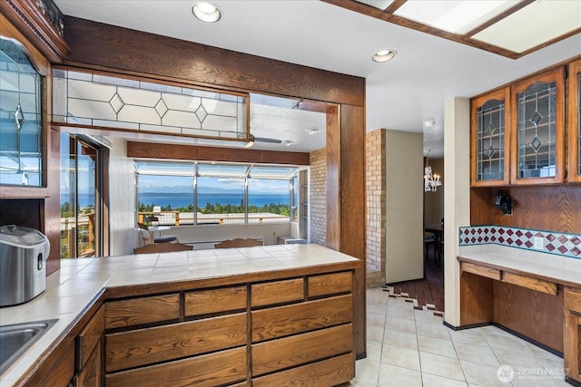 1125 Vista Pl, Edmonds, WA 98020 - kitchen featuring tile counters, brown cabinetry, light tile patterned flooring, glass insert cabinets, and recessed lighting
