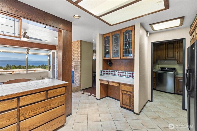 1125 Vista Pl, Edmonds, WA 98020 - kitchen with range, freestanding refrigerator, light tile patterned flooring, glass insert cabinets, and tile counters