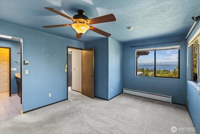 1125 Vista Pl, Edmonds, WA 98020 - unfurnished bedroom with a baseboard radiator, carpet floors, connected bathroom, and ceiling fan