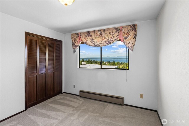 1125 Vista Pl, Edmonds, WA 98020 - unfurnished bedroom with a baseboard heating unit, a closet, and light carpet