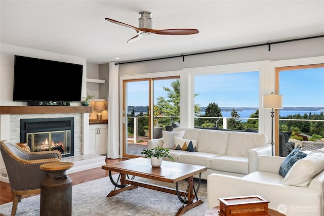 1871 Hillside Dr NE, Tacoma, WA 98422 - living area featuring ceiling fan, a glass covered fireplace, wood finished floors, and healthy amount of natural light