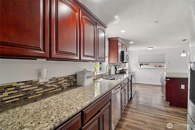 6817 S D St, Tacoma, WA 98408 - kitchen featuring reddish brown cabinets, stainless steel appliances, dark wood finished floors, tasteful backsplash, and light stone countertops