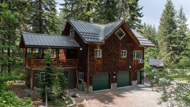 7905 Mountain Home Rd, Leavenworth, WA 98826 - view of front facade with a standing seam roof, an attached garage, a metal roof, and driveway