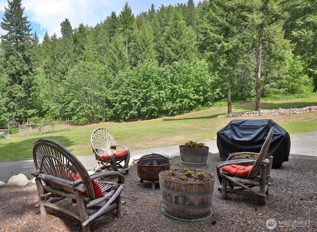 7905 Mountain Home Rd, Leavenworth, WA 98826 - view of patio / terrace featuring an outdoor fire pit, grilling area, and a wooded view