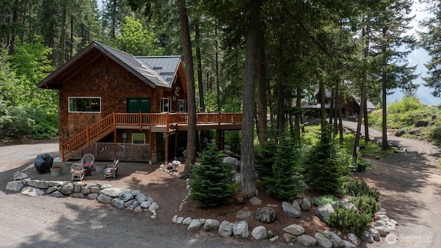 7905 Mountain Home Rd, Leavenworth, WA 98826 - view of front of property with a wooden deck, a metal roof, a patio, a standing seam roof, and a fire pit
