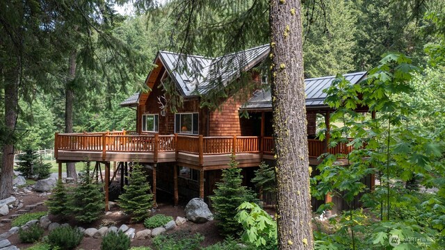 7905 Mountain Home Rd, Leavenworth, WA 98826 - rear view of house with a standing seam roof, a deck, a view of trees, and a metal roof