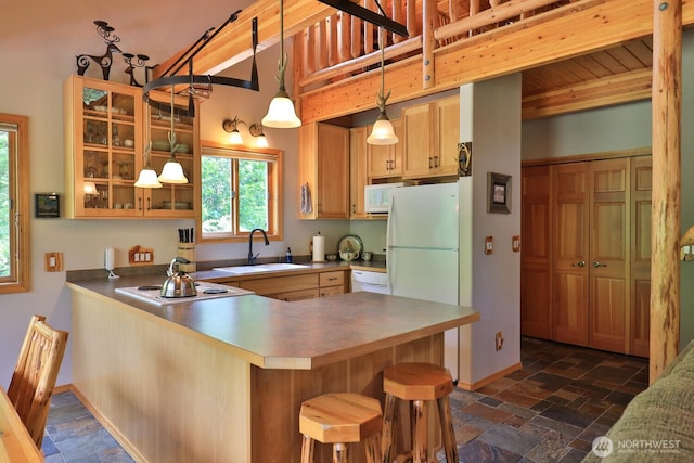7905 Mountain Home Rd, Leavenworth, WA 98826 - kitchen featuring stone tile flooring, white appliances, a peninsula, and glass insert cabinets