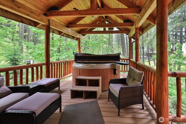 7905 Mountain Home Rd, Leavenworth, WA 98826 - wooden deck featuring a hot tub, a wooded view, and an outdoor hangout area
