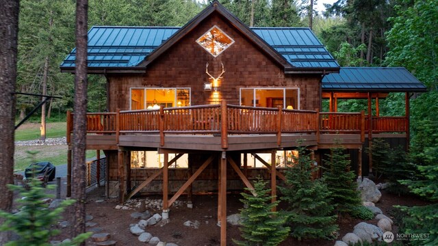 7905 Mountain Home Rd, Leavenworth, WA 98826 - back of property featuring a standing seam roof, a metal roof, a wooden deck, and a wooded view