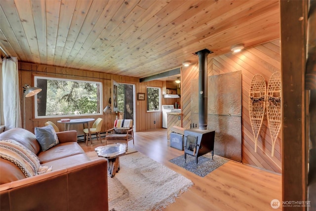 12319 744th Ave NE, Skykomish, WA 98288 - living area with a wood stove, wood ceiling, wood walls, a baseboard heating unit, and wood finished floors