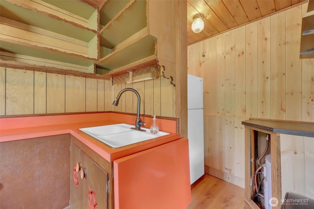12319 744th Ave NE, Skykomish, WA 98288 - kitchen with freestanding refrigerator, wood walls, and light wood-style flooring