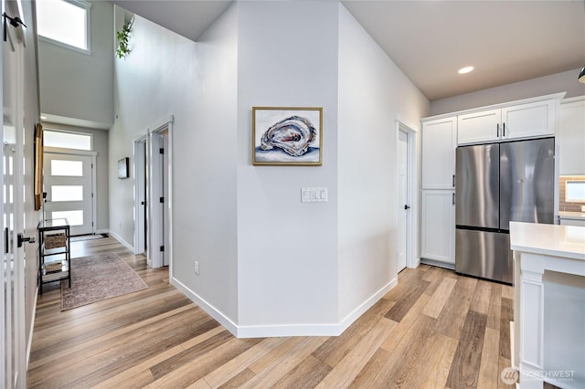 1995 NW Rustling Fir Ln, Silverdale, WA 98383 - kitchen with stainless steel fridge, light wood-type flooring, white cabinets, light countertops, and recessed lighting