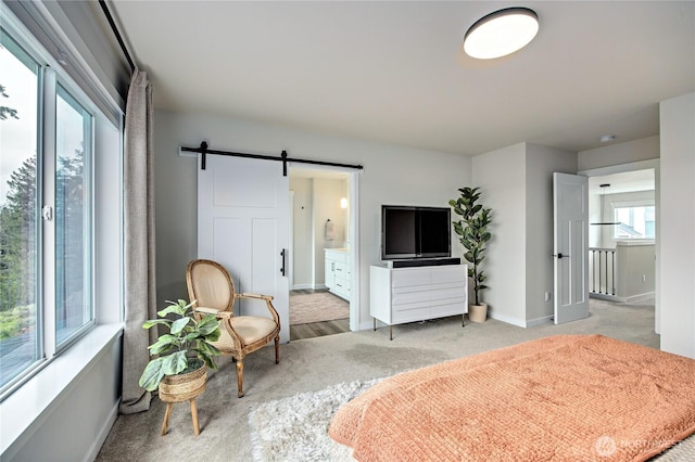 1995 NW Rustling Fir Ln, Silverdale, WA 98383 - bedroom featuring a barn door, ensuite bathroom, and light colored carpet