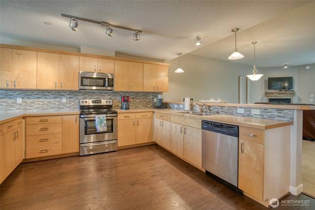 262 Oyhut Bay Blvd SW Unit 204, Ocean Shores, WA 98569 - kitchen featuring stainless steel appliances, light brown cabinetry, a peninsula, decorative backsplash, and a textured ceiling