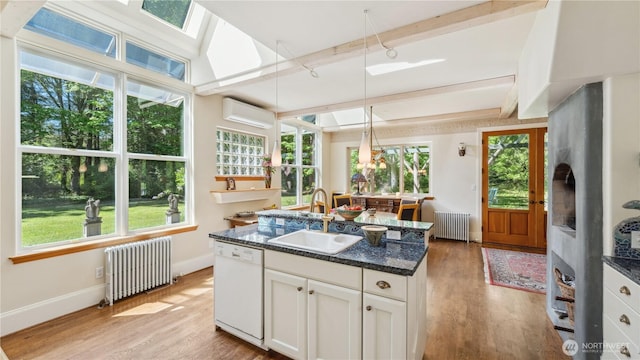 5513 Homestead Ln, Anacortes, WA 98221 - kitchen with radiator, white dishwasher, an AC wall unit, light wood-style flooring, and beam ceiling