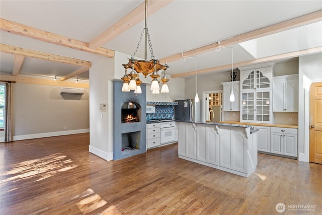 5513 Homestead Ln, Anacortes, WA 98221 - kitchen featuring freestanding refrigerator, white oven, beam ceiling, a kitchen breakfast bar, and light wood-style floors