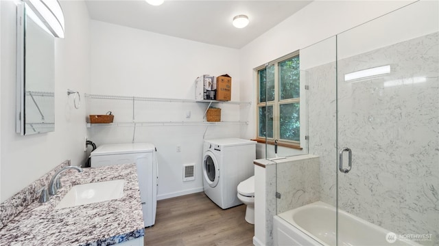 5513 Homestead Ln, Anacortes, WA 98221 - bathroom with independent washer and dryer, wood finished floors, vanity, and enclosed tub / shower combo