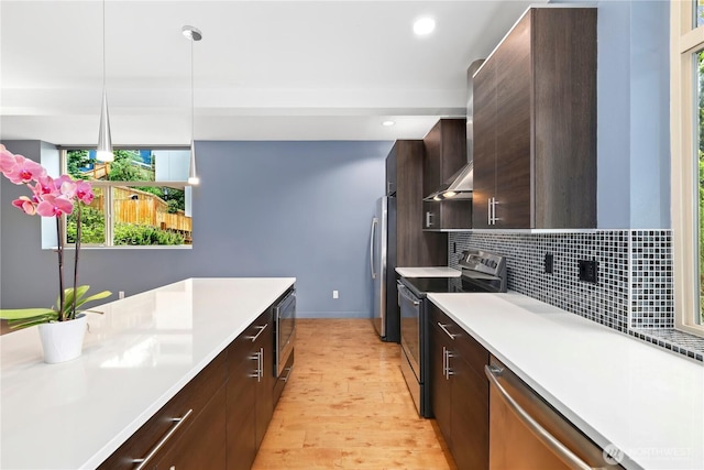 7528 21st Ave SW, Seattle, WA 98106 - kitchen with appliances with stainless steel finishes, light countertops, light wood-style floors, decorative backsplash, and dark brown cabinets