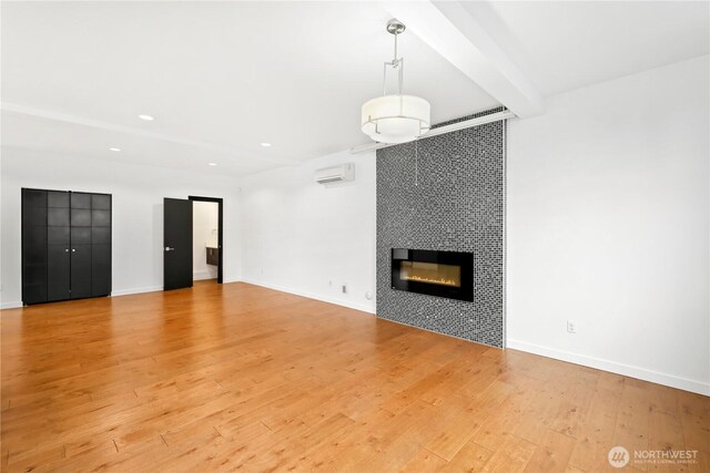 7528 21st Ave SW, Seattle, WA 98106 - unfurnished living room with light wood-style floors, a tile fireplace, recessed lighting, and a wall mounted AC