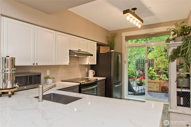 23300 SE Black Nugget Rd Unit J3, Issaquah, WA 98029 - kitchen with appliances with stainless steel finishes, under cabinet range hood, tasteful backsplash, light stone counters, and white cabinetry