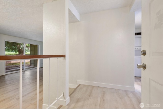 17514 151st Ave SE Unit 1-4, Renton, WA 98058 - hallway with wood finished floors, a textured ceiling, and stacked washing machine and dryer