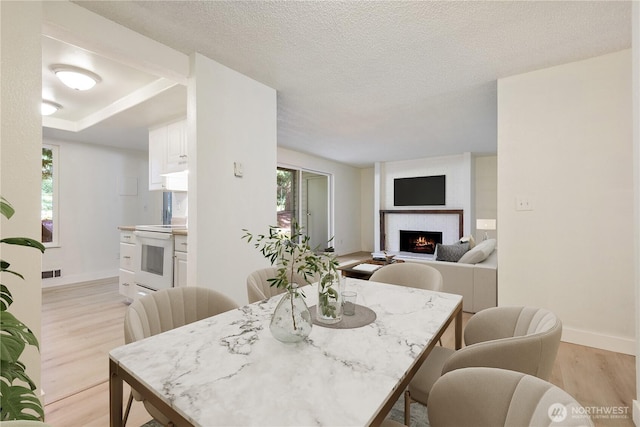 17514 151st Ave SE Unit 1-4, Renton, WA 98058 - dining area featuring light wood finished floors, plenty of natural light, and a brick fireplace