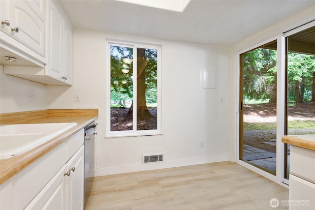 17514 151st Ave SE Unit 1-4, Renton, WA 98058 - kitchen with dishwasher, light wood-type flooring, white cabinets, and light countertops