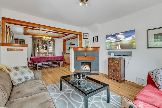 4222 Latona Ave NE, Seattle, WA 98105 - living area featuring wood finished floors, a tiled fireplace, and a chandelier